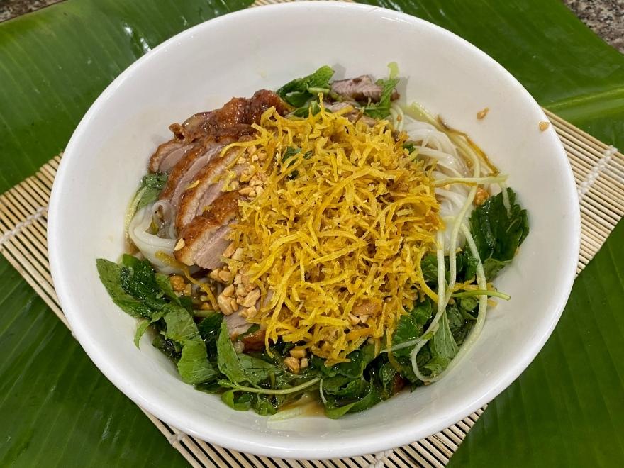 A traditional bowl of Cao Bang Sour Pho (Pho Chua) with roasted duck and peanuts, a warming local specialty for the cold 10°C mountain nights.