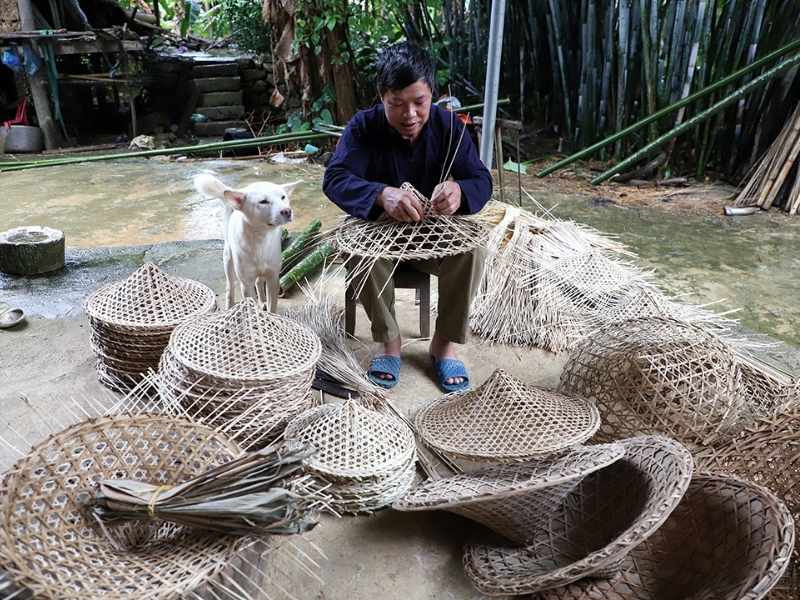 A Nung An artisan is weaving a conical hat.