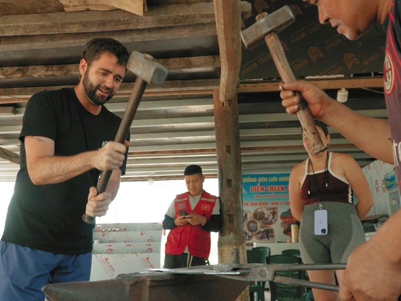 Tourists Cao Bang Eco Travel experience knife forging at Phuc Sen craft village.